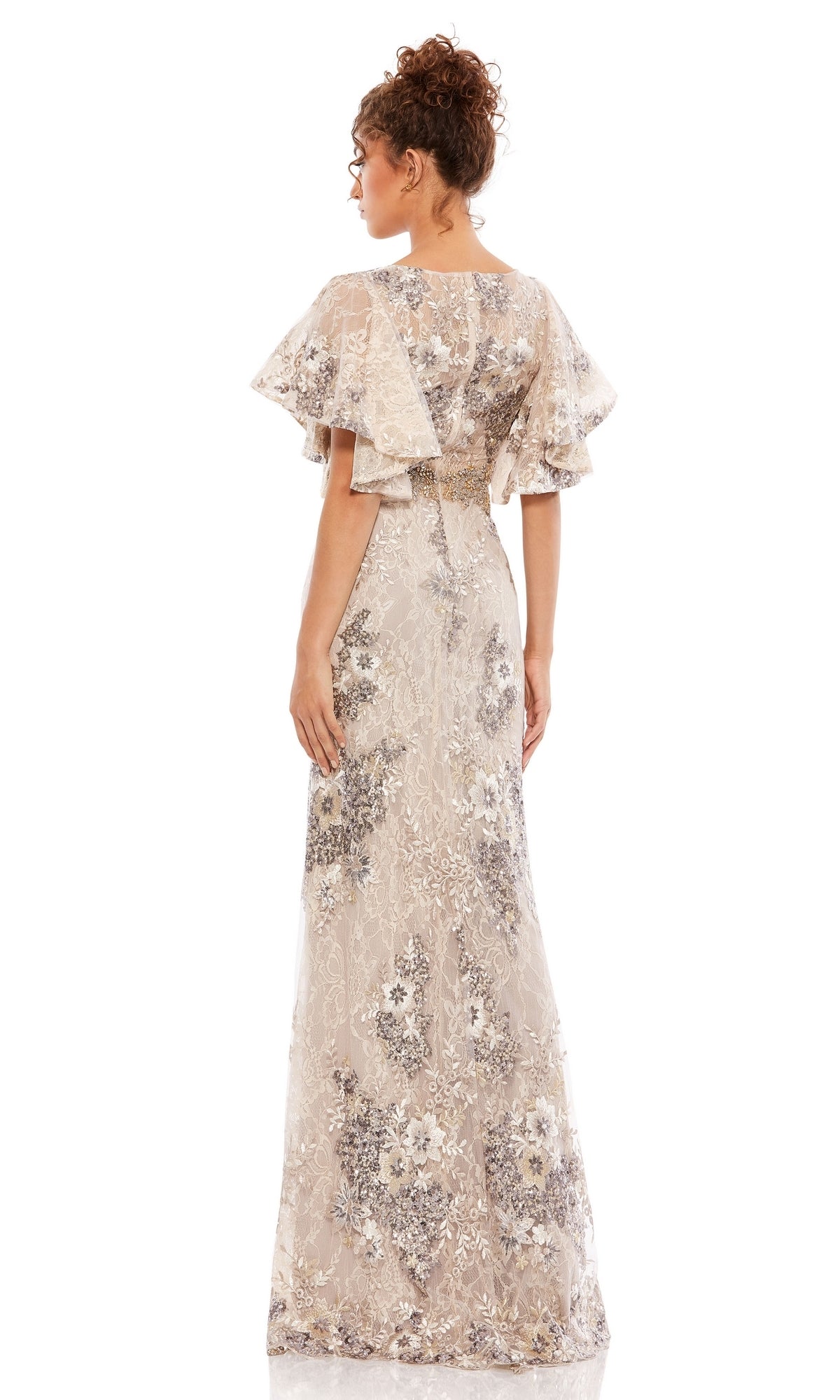 A woman faces away, wearing the Mac Duggal 67842 Flutter-Sleeve Long Formal Dress with sheer floral fabric and intricate lace detailing.